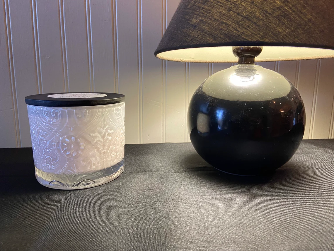 A table with a candle and a lamp on it