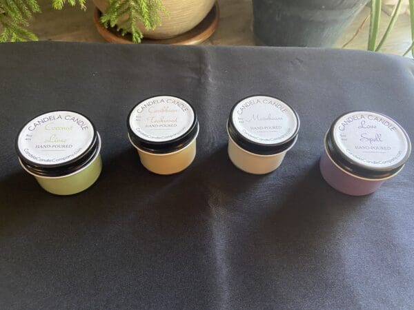 A table with four jars of different colored creams.