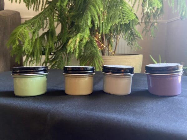 A table with four jars of different colored creams.