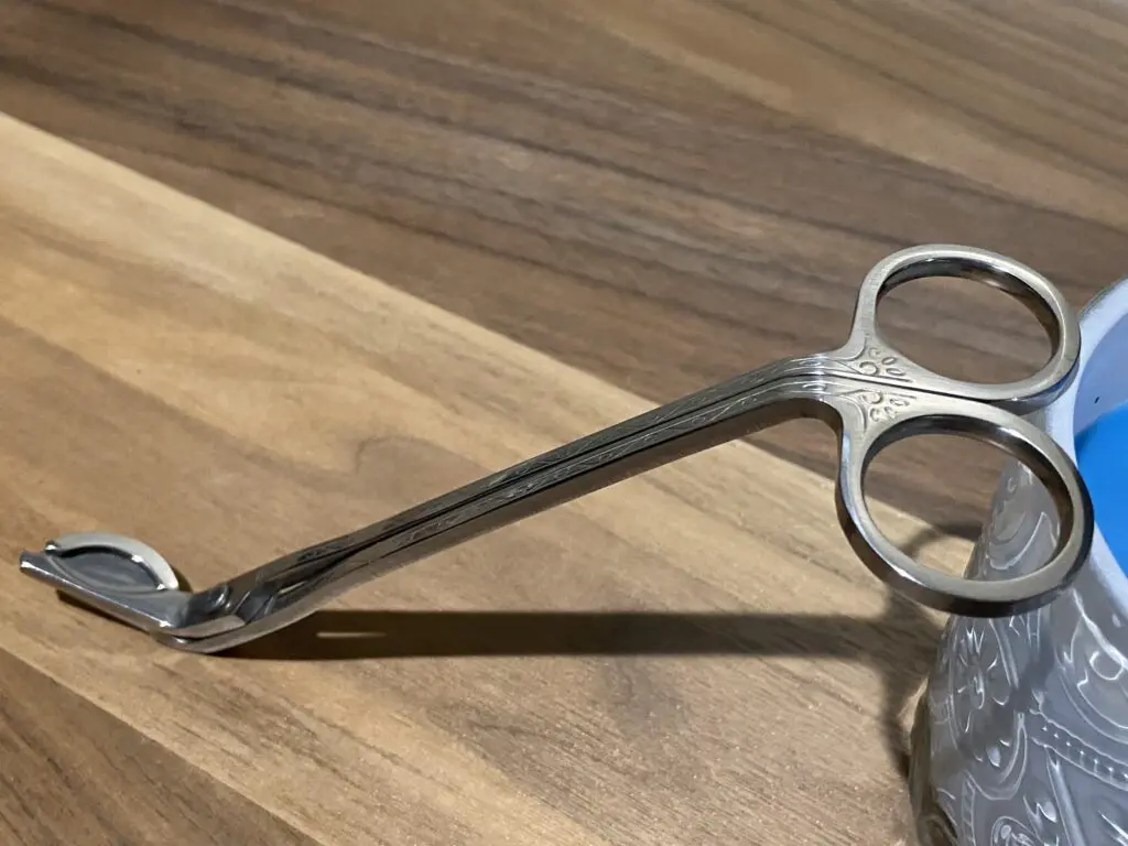 A pair of scissors sitting on top of a wooden table.