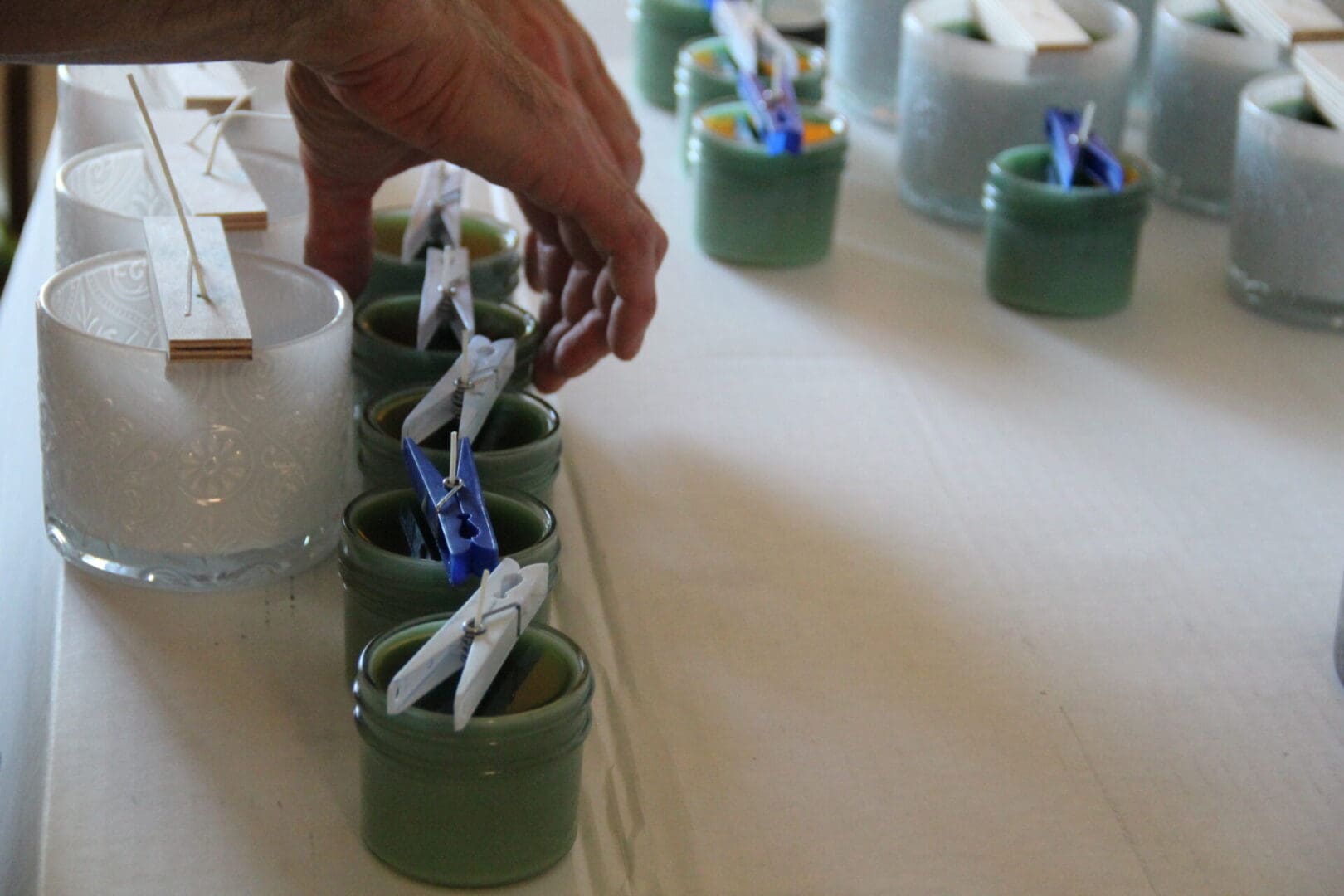 A person is putting toothbrushes in the cups.